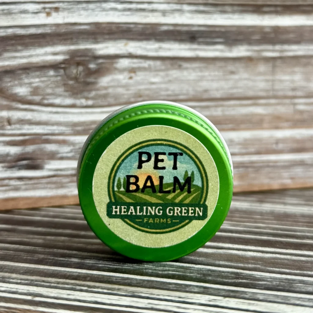 A container labeled "Pet Balm" sits on a wooden surface in front of a rustic, wood-paneled background.